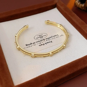 Detail of a vintage gold-plated textured open bangle with small crystals in a gift box