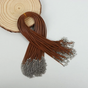 Detail of brown wax cord necklace with silver lobster clasps on a wooden display