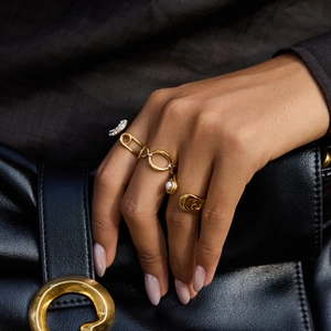Ensemble de bagues dorées 18 carats avec perles et cristaux sur fond de cuir noir raffiné