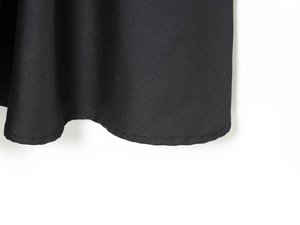 Detailed close-up of the stitching and hem texture on a black blazer dress