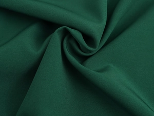 Vista macro dettagliata della trama del tessuto verde e dell'elegante drappeggio pieghettato