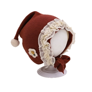 Knit baby bonnet with white lace trim and floral embroidery in reddish brown color
