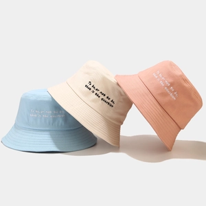 Embroidered cotton bucket hats in blue, white, and pink with literary quote detail