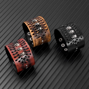 Three punk leather wristbands in black, red and brown with skull and stud details