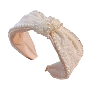 Creamy white pleated fabric headband with faux pearl trim and a vintage knot design