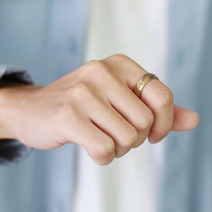 Detail shot of a two-tone minimalist stainless steel ring worn on the pinky finger
