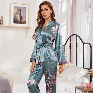 Détail d'un pyjama en satin de soie vert foncé avec fleurs, dentelle et col en V