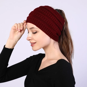 Detail view of burgundy knitted headband showing high ponytail opening and soft wool texture
