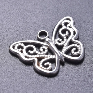 Macro detail of silver stainless steel butterfly pendant with hollowed dot texture