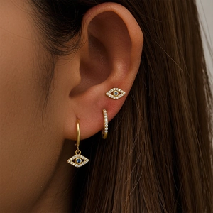 Close-up of S925 silver gold evil eye and star moon diamond earring set on ear