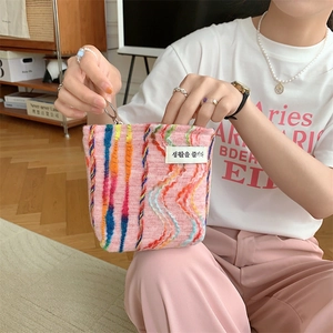 Détail du sac tricoté rose avec broderie rayée arc-en-ciel et fermeture éclair argentée