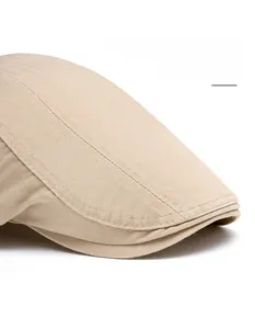 Detail of the foldable wide brim and stitching on this khaki herringbone flat cap