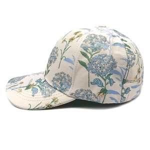 Dettaglio di cappello jacquard con ortensie blu e ricami floreali gialli su bianco