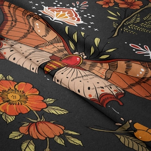 Detailaufnahme der weichen Samtstoff-Textur mit Motten- und orangefarbenem Blumenmuster