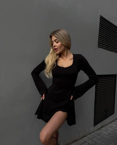Détail de la robe courte noire à manches longues avec décolleté en U et coupe moulante