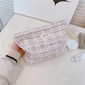 Macro detail of lavender tweed makeup bag with woven texture and a simple wish label