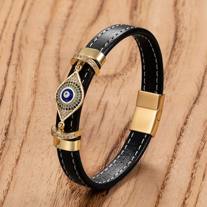 Dettaglio del charm malocchio su bracciale in pelle nera con chiusura magnetica d'oro