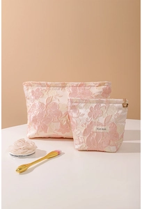 Detail of floral embossed texture on the large and small makeup bag set with gold zippers