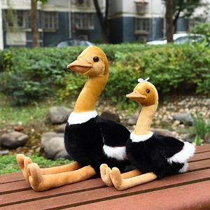 Plush ostrich toy set with soft black fur and beige long necks on a wooden bench