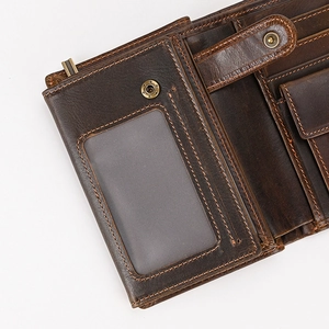 Detail view of genuine leather wallet featuring ID window and bronze snap fastener