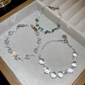 Vue détaillée de trois bracelets fleurs en cristal sur un plateau en velours gris