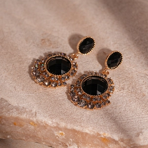 Vue macro de boucles d'oreilles vintage fleurs noires serties sur support en pierre naturelle