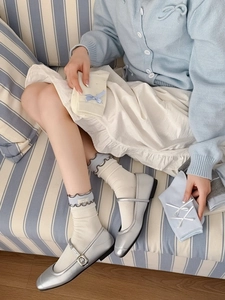 Détail de chaussettes en coton avec nœuds délicats et bordures ondulées élégantes