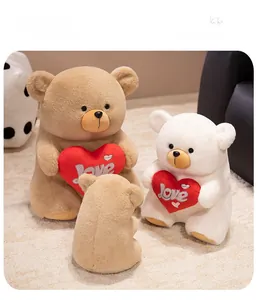 Detailed view of plush teddy bears in brown and white holding embroidered red hearts