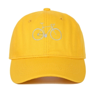 Detailed close-up of high-quality silver bicycle embroidery on a yellow cotton baseball cap