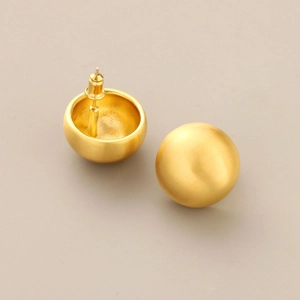 Detailed view of matte gold brushed sphere earrings featuring a minimalist ball design
