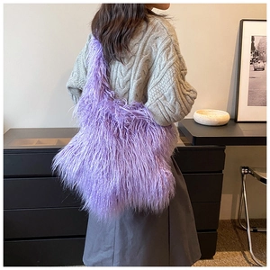 Detail view of a purple plush shoulder bag showing texture and oversized design on model