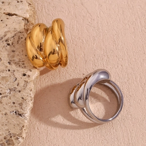 Detail view of 18K gold and silver dome rings with wavy intertwined texture on stone