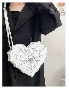 Détail du sac à bandoulière blanc en forme de cœur avec motif de toile d'araignée noire