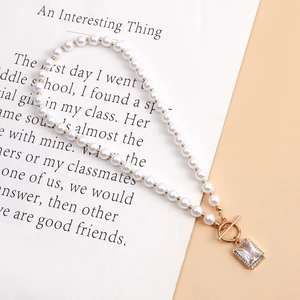 Detail of pearl necklace with gold OT buckle and rectangular rhinestone pendant