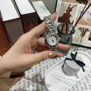 Montre femme argentée classique avec chiffres romains sur cadran blanc élégant