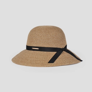 Detail of natural straw hat with black ribbon bow and elegant gold metal logo plate