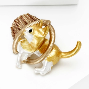 Detail of cute cat enamel brooch featuring a golden woven basket on white background