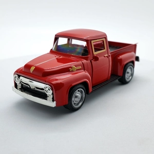 Close-up of a vintage red diecast pickup truck with gold trim and metallic finish
