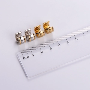 Polished two-tone and gold stainless steel hoop earrings shown with a measuring ruler
