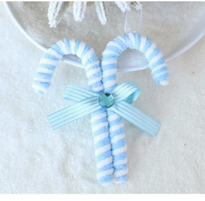 Close-up of blue and white striped foam candy cane ornament with a bow and blue gem detail