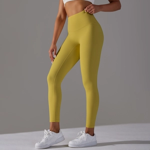 Detail showing mustard yellow high-waisted yoga leggings with seamless athletic fit