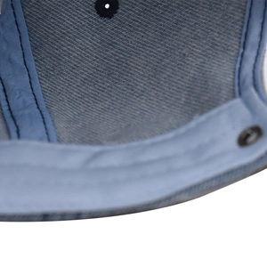 Détail intérieur d'une casquette en denim bleu montrant la bande et les coutures