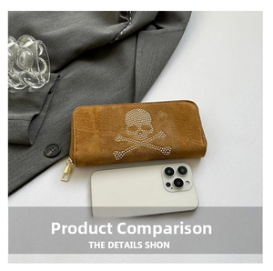 Close-up of brown suede long wallet featuring rhinestone skull and gold zipper detail