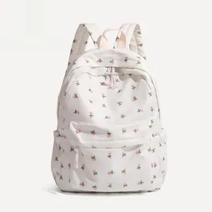 Detail view of floral canvas backpack with pink flower patterns and front zipper pocket