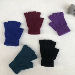 Flat lay of five pairs multi-color knit fingerless gloves on white plush background