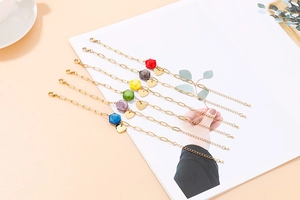 Detailed view of colorful faceted beads and heart charms on adjustable gold bracelets