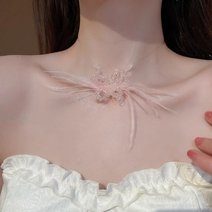 Detailed view of pink feather and beaded butterfly necklace on a model's neck