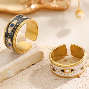 Detailed close-up of gold-plated evil eye rings with black and white enamel finishes