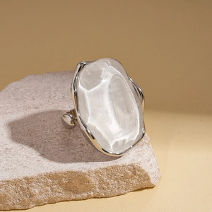 Irregular silver frame ring with large oval white resin stone on a natural stone base