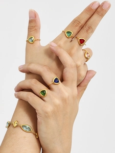 Detail van 18k vergulde driehoekige edelsteenringen en bijpassende kleurrijke armband